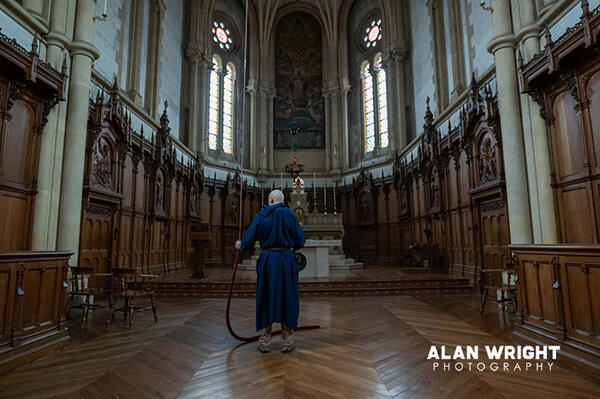A monk in blue habits (they also wear white) rings the church bell (©AAH/Alan Wright)